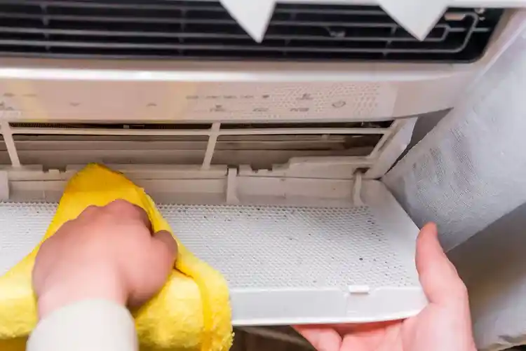 تنظيف مكيف الشباك يدوياً لإزالة الغبار المتراكم على الفلاتر والواجهة الأمامية