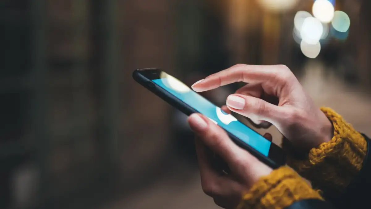 شخص يستخدم تطبيق صيانة المكيفات على الهاتف الذكي لطلب خدمة منزلية.