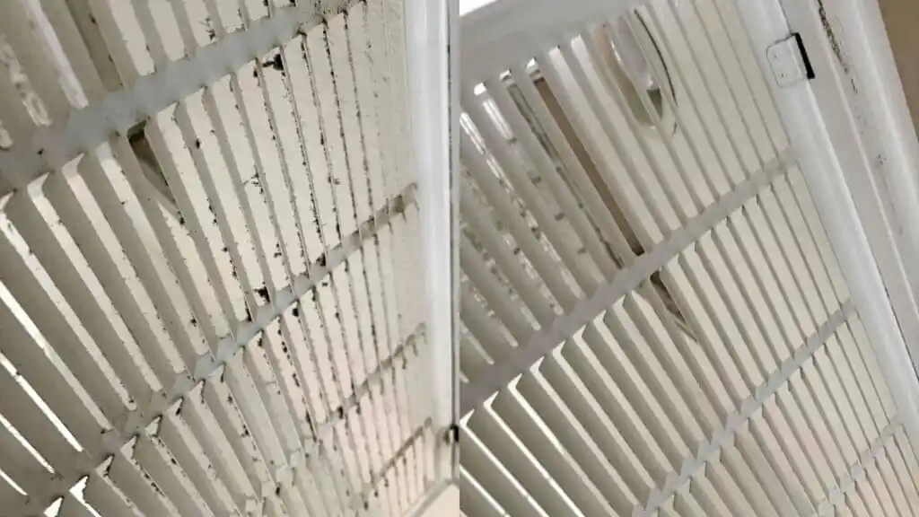 فتحات مكيف هواء في مبنى سكني تظهر تراكم التراب على الشفرات والشبكات، مما يوضح تأثير الغبار على كفاءة الهواء.