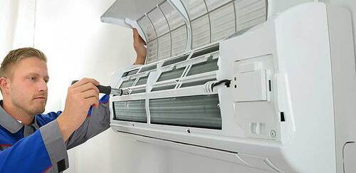 فني صيانة محترف يقوم بفحص وإصلاح مكيف سبليت في المنزل