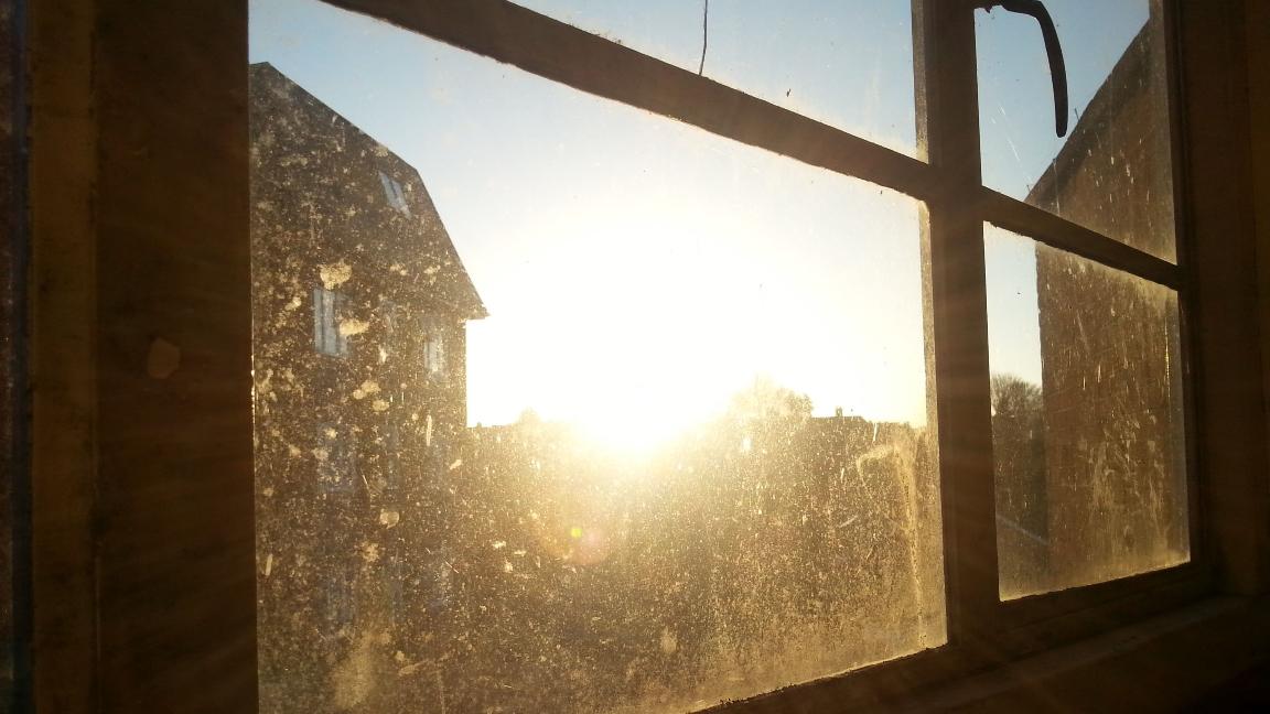 نافذة متسخة تراكمت عليها الأتربة والغبار بسبب المناخ الصحراوي