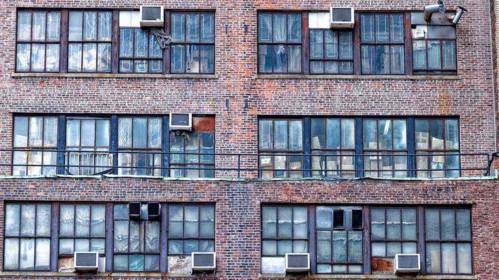 وحدات تكييف خارجية في مبنى سكني توضح أهمية صيانة أنظمة التبريد في الشقق القديمة